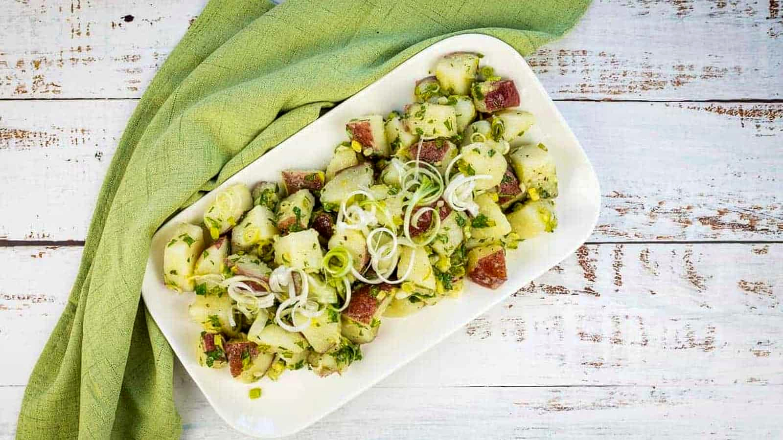 Herbed potato salad on a white platter.
