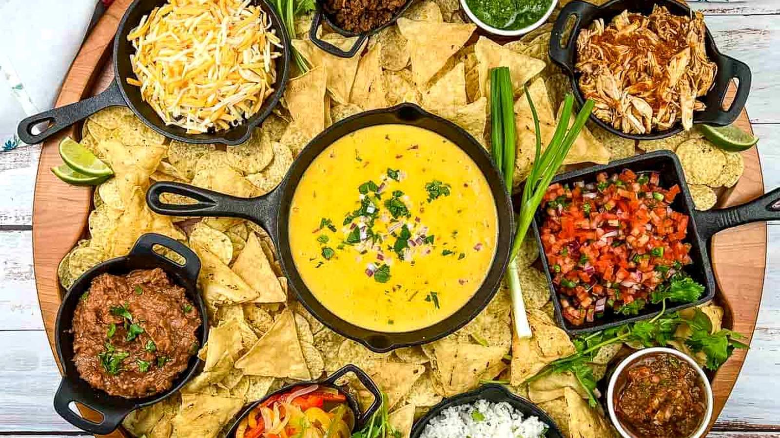 A platter of nachos with different toppings.