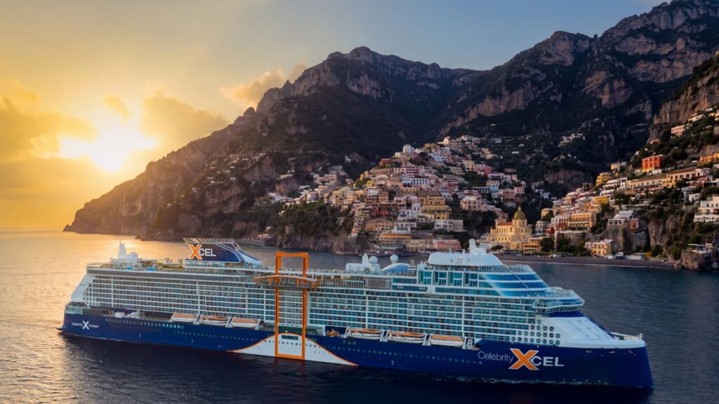 A large Celebrity Cruises ship sails near a coastal town with colorful buildings on a steep hillside at sunset, capturing the breathtaking allure of their 2028 and 2029 voyages.