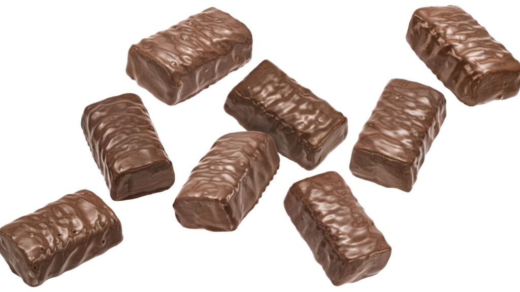Eight rectangular chocolate bars with a textured, wavy surface are spread out on a white background—a nostalgic reminder of candy snacks you can’t buy anymore.