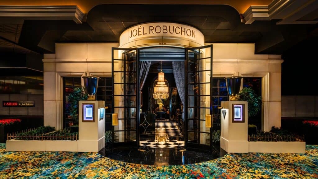 Luxurious restaurant entrance with elegant decor and chandeliers.