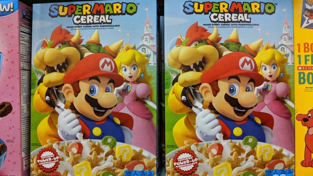 Super Mario Cereal boxes featuring Mario, Princess Peach, and Bowser, with colorful marshmallow cereal pieces shown at the bottom of the box&mdash;these discontinued breakfast cereals are now sought-after collectibles for fans and nostalgia lovers alike.
