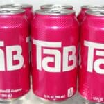 Six pink cans of Tab soda, each 12 fl oz (355 ml), are arranged in two rows inside a refrigerator—a nostalgic nod to sodas that had their moment.