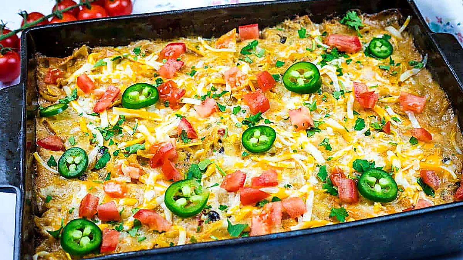 A close-up of a partially eaten cheesy Mexican chicken casserole in a baking dish.