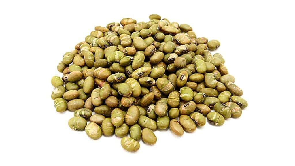 A pile of dried green mung beans is displayed on a white background.