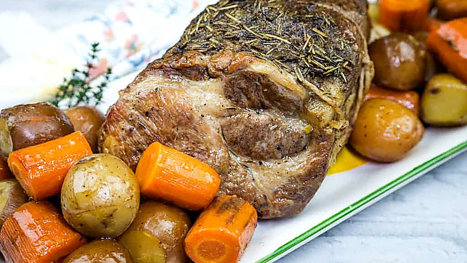 A plate with a Slow Cooker Herb-Crusted Pork Roast and roasted vegetables.