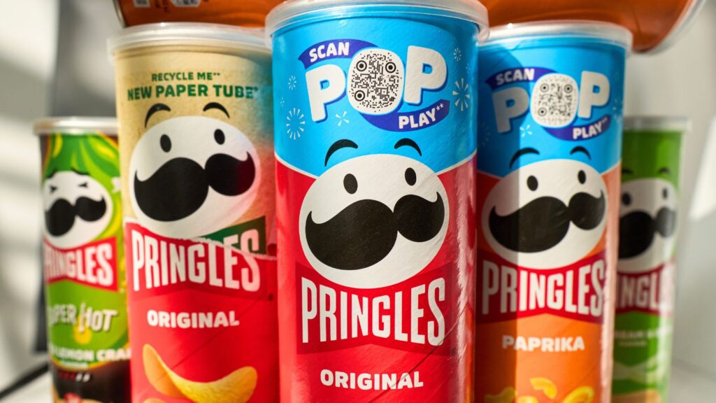 Five Pringles cans in various flavors, including Original and Paprika, are displayed upright, featuring the brand&rsquo;s logo and colorful packaging designs.