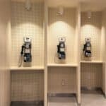 Four vintage rotary payphones in separate beige alcoves, each with a sign indicating a cost of 10 cents per call&mdash;a nostalgic reminder of the payphone booth designs America left behind.