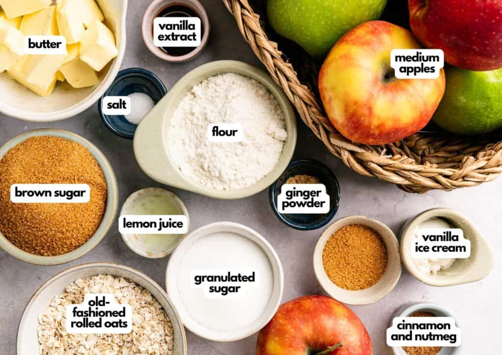 Overhead view of labeled apple crisp ingredients, including apples, butter, flour, sugars, oats, spices, vanilla extract, lemon juice, ginger powder, and a bowl of vanilla ice cream.