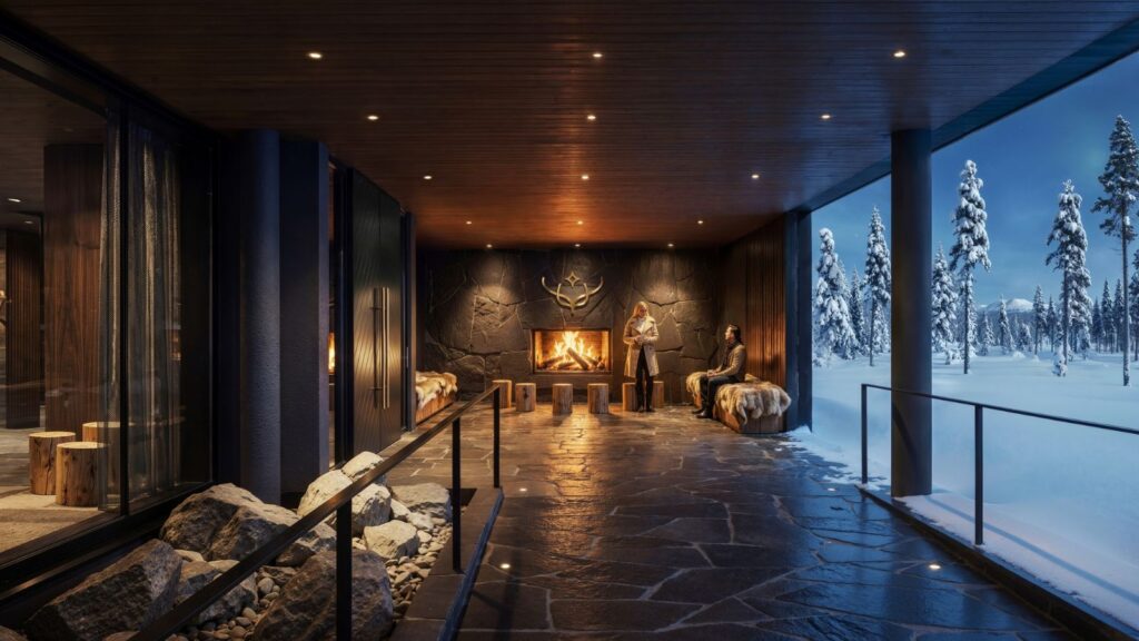 A modern covered patio with a stone floor and fireplace, seating, and two people. Snowy trees and landscape are visible outside in the evening light.