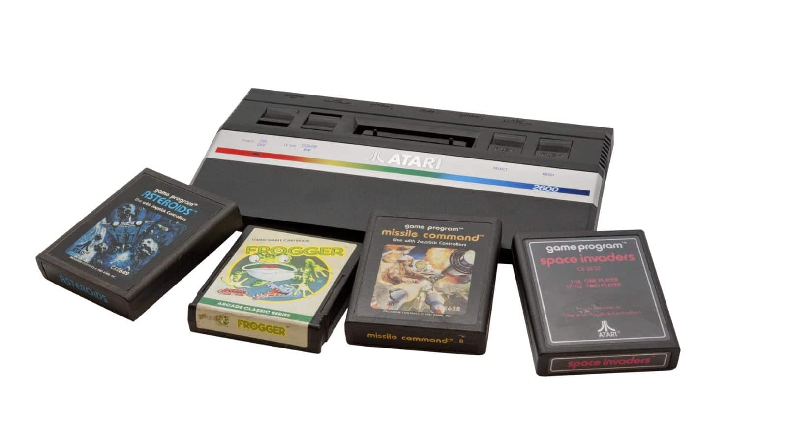 An Atari 2600 game console is shown with four game cartridges—Asteroids, Frogger, Missile Command, and Space Invaders—displayed on a white background, evoking classic Atari memories for retro gaming enthusiasts.