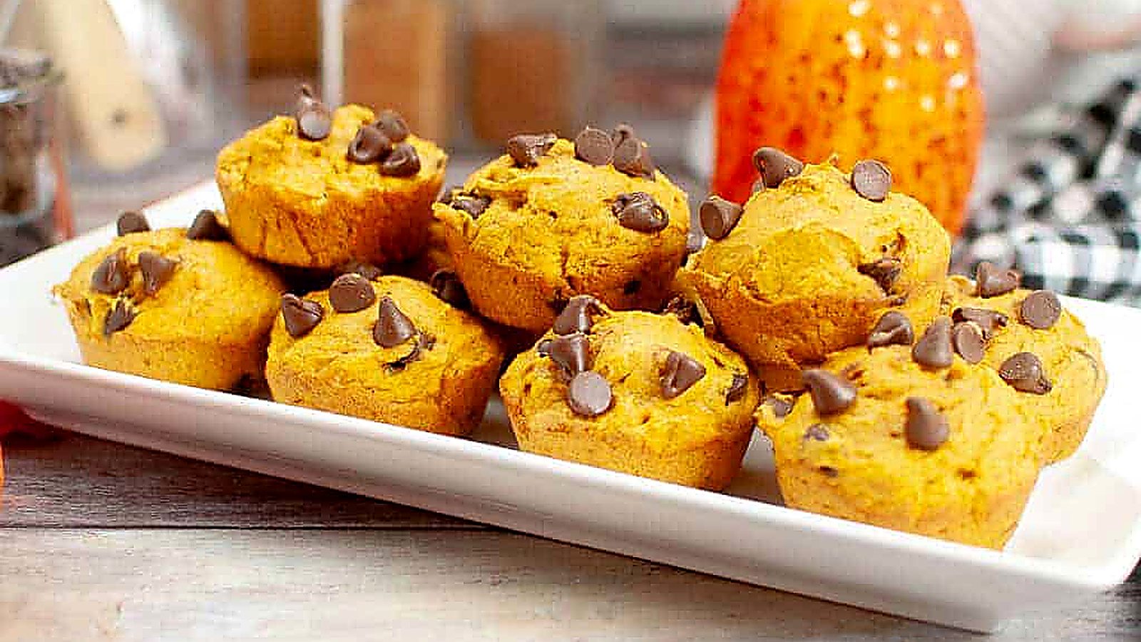 A white rectangular plate Cake Mix Pumpkin Spice Muffin topped with chocolate chips.