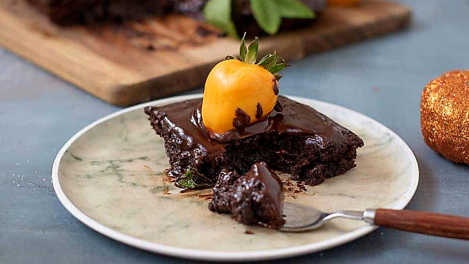 A slice of Chocolate Pumpkin Patch Brownie Cake sits on a plate, accompanied by a fork.