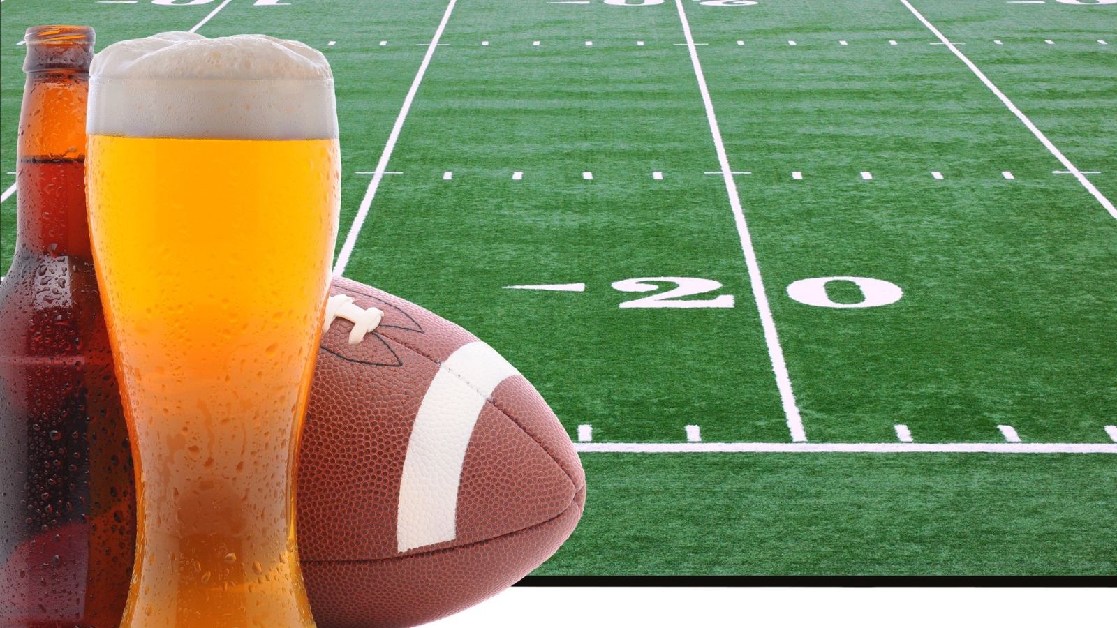 A glass of beer, a bottle, and a football are set in front of a football field marked with yard lines, evoking the atmosphere of game day and sparking conversation about NFL stadium beer prices.