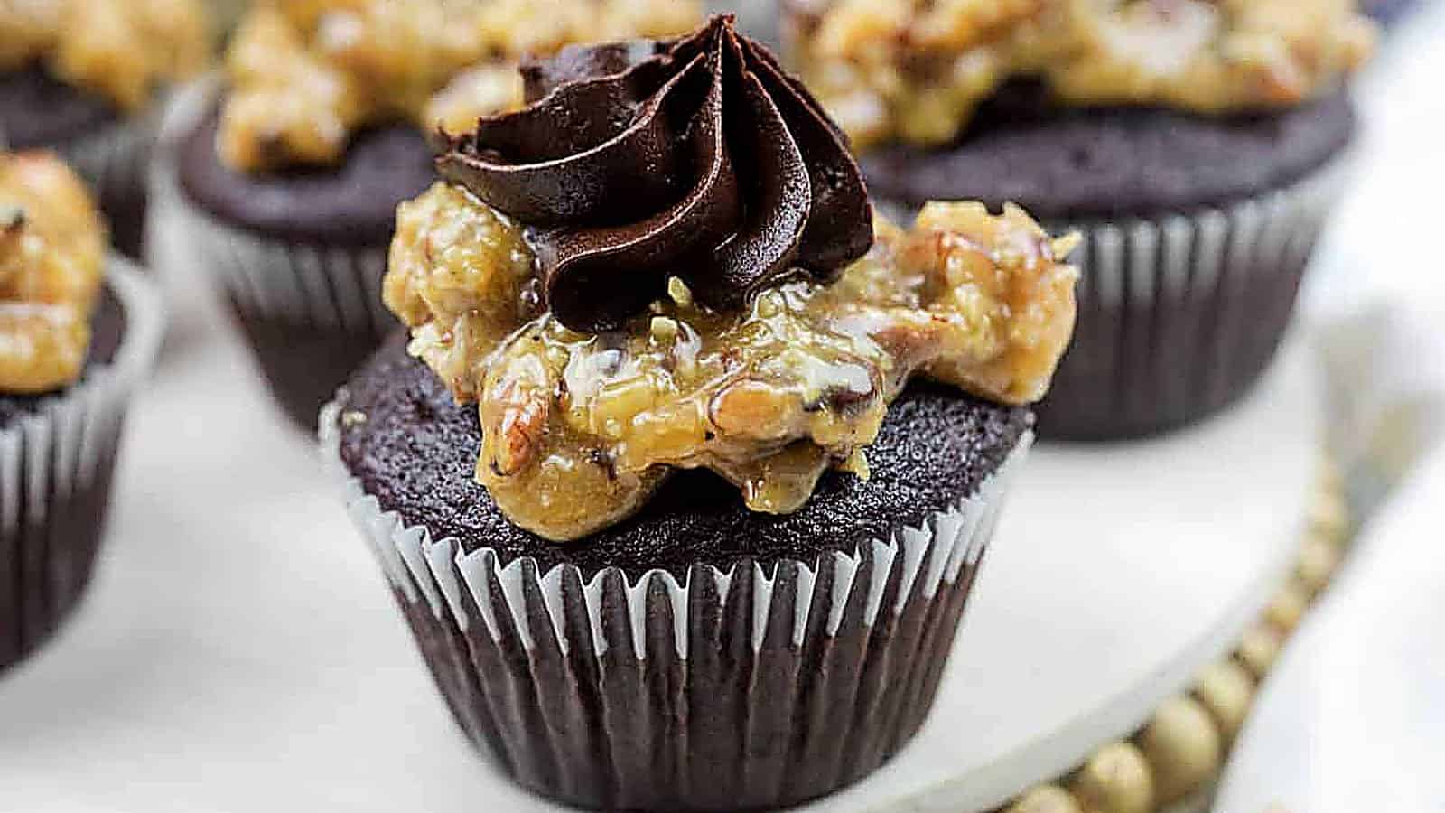 Close-up of German chocolate cupcake topped with coconut-pecan caramel and a swirl of chocolate buttercream.