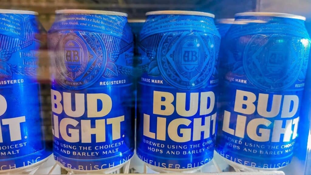 Three blue Bud Light beer cans are displayed side by side on a refrigerator shelf, showing their brand name and logo clearly on the front&mdash;a perfect nod to NFL stadium beer culture.