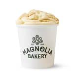 Magnolia Bakery banana pudding in a white cup with logo, creamy and inviting.