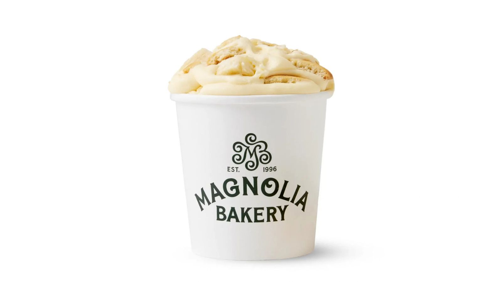 A white Magnolia Bakery cup filled with swirled banana pudding and wafer pieces, set against a plain white background.