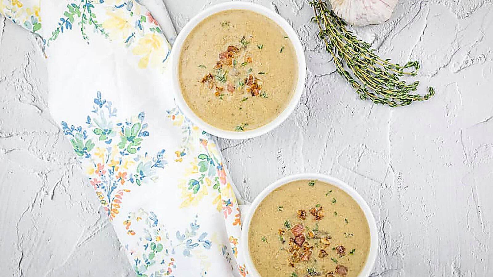 Two bowls of cream of caramelized onion & mushroom soup with garlic and thyme.