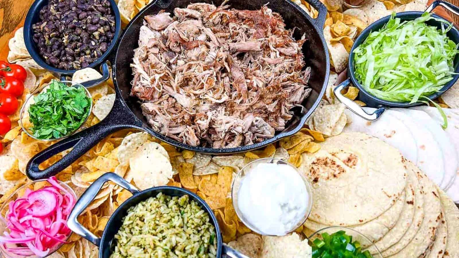 A platter of pork carnitas board on a wooden table.