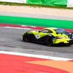 A yellow and black race car with the number 111 drives on a racetrack with colorful red, green, and white sections.