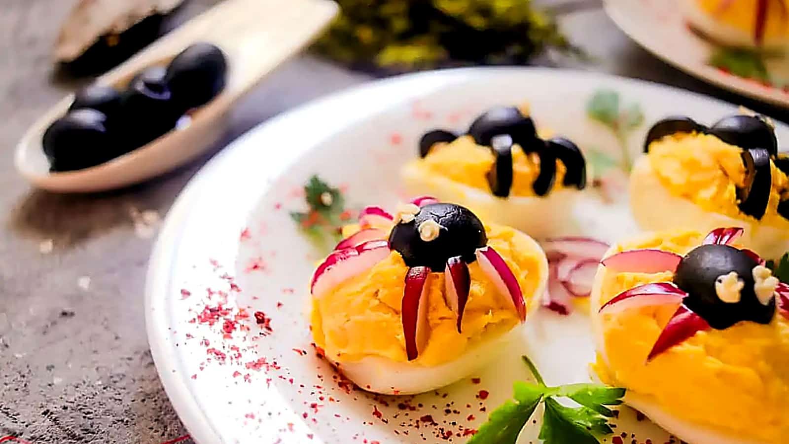 Deviled eggs with black olive spiders.