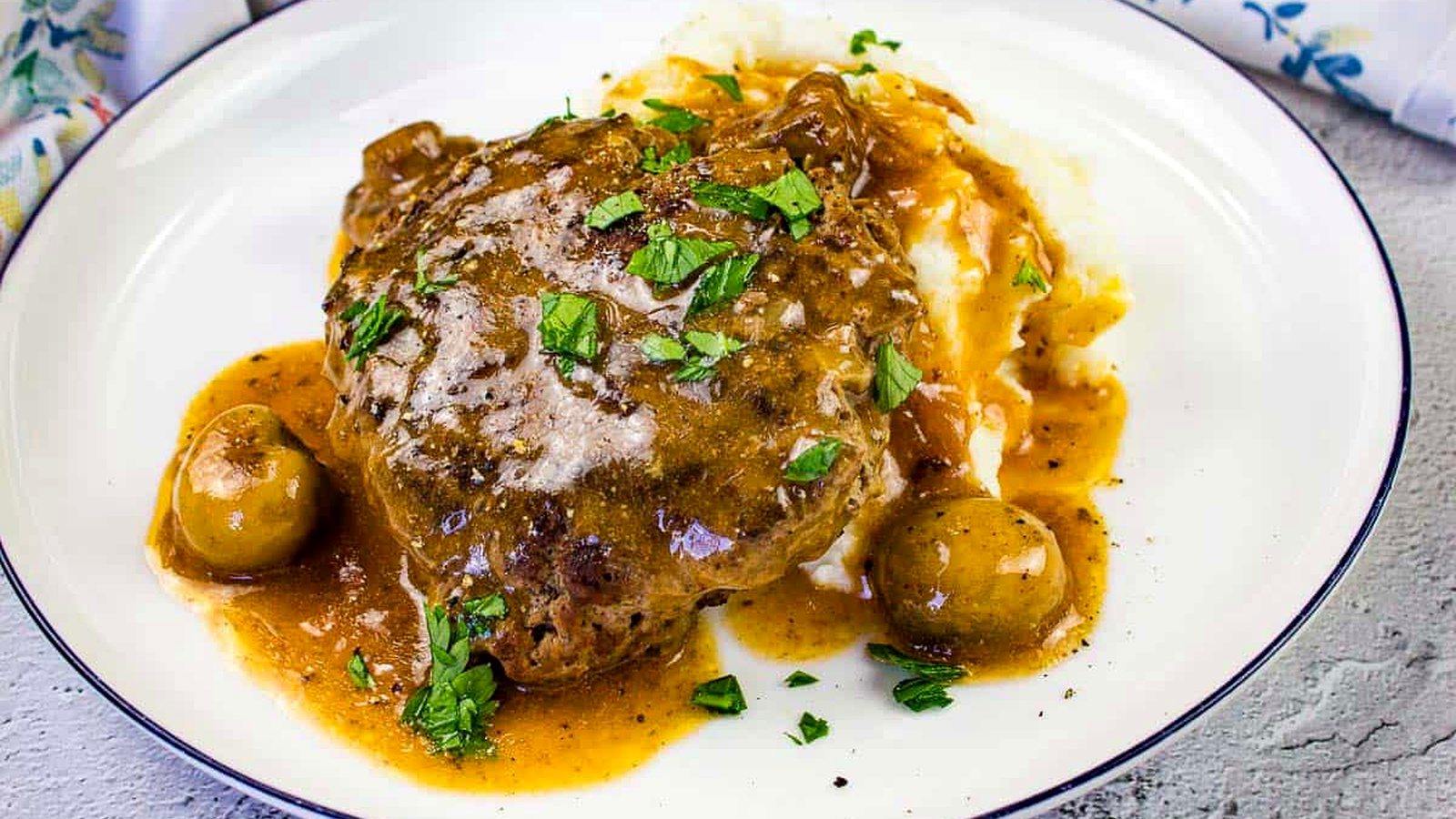 Salisbury Steak on a bed of mashed potatoes.