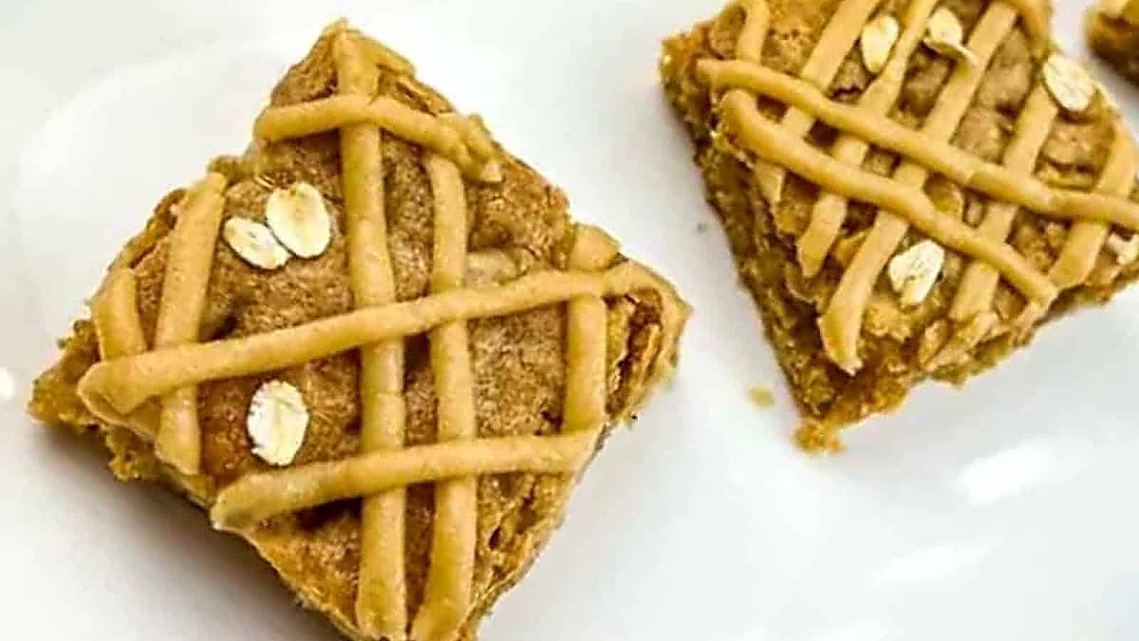 Two brown butter apple blondies were placed on a white surface.