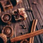 A chai bath melts recipe decorated with star anise, cinnamon sticks, and cloves on a wooden surface, evoking a cozy fall beauty routine.