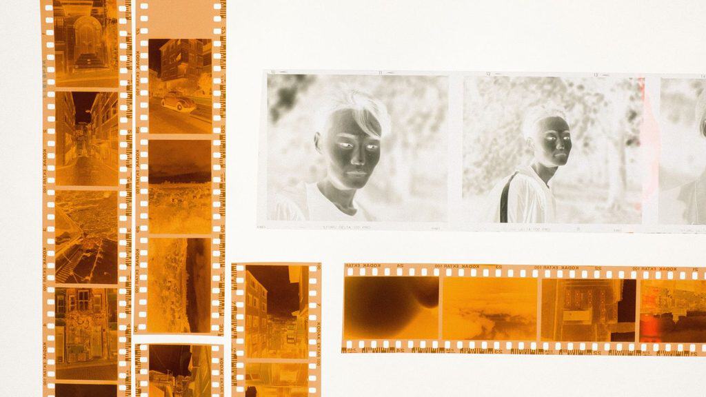Strips of 35mm film negatives showing architectural scenes and portraits that evoke one hour photo memories.