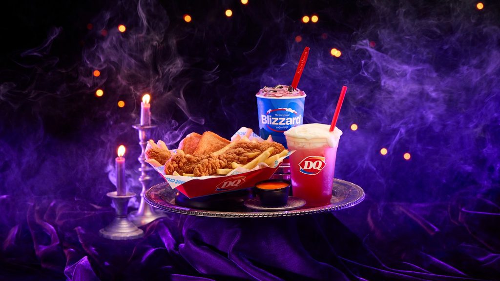 A Dairy Queen meal including a chicken strip basket, a Blizzard, and a red drink on a silver tray surrounded by purple fog and candlelight.