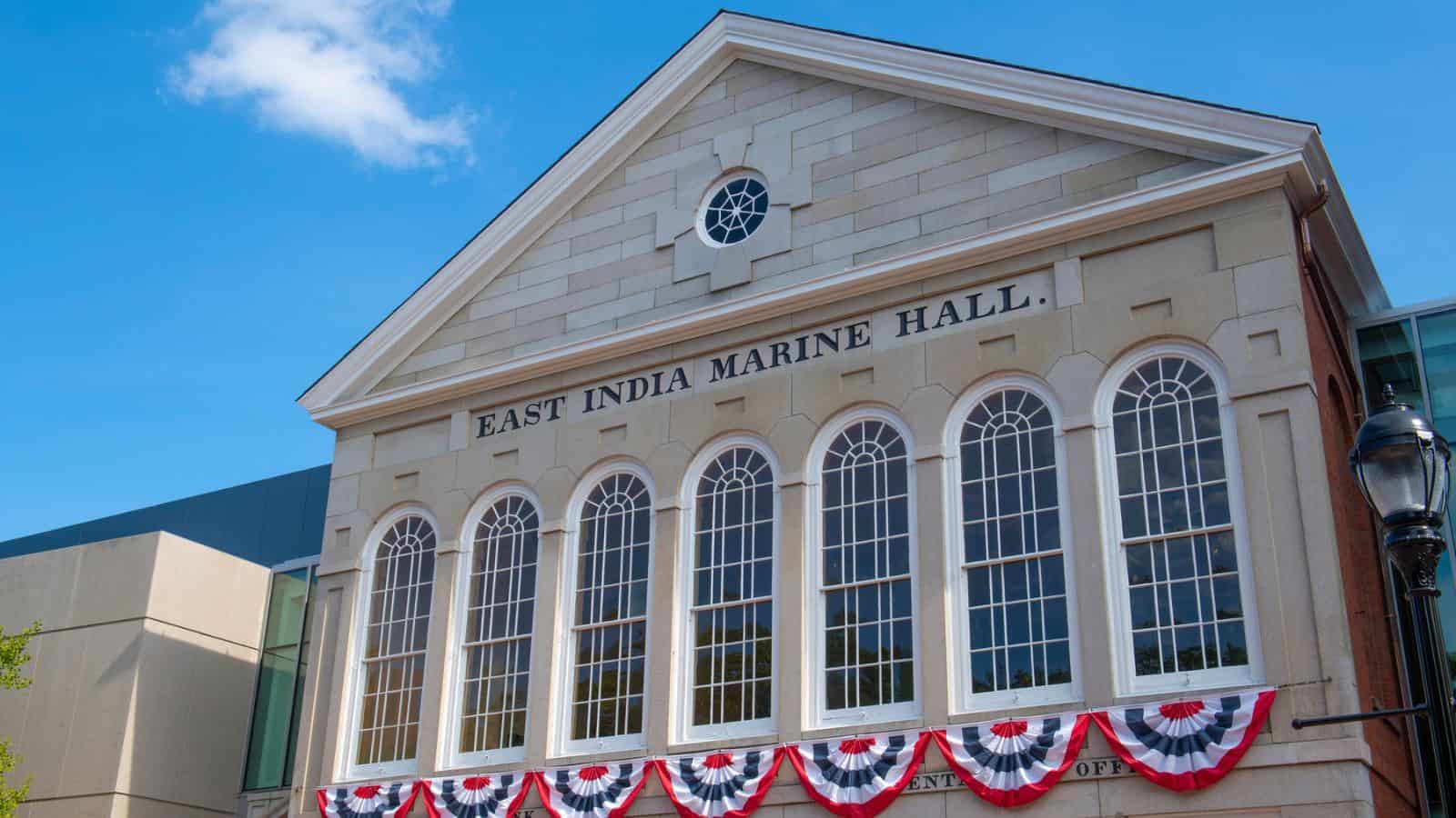 The facade of East India Marine Hall, featuring arched windows and red, white, and blue bunting.