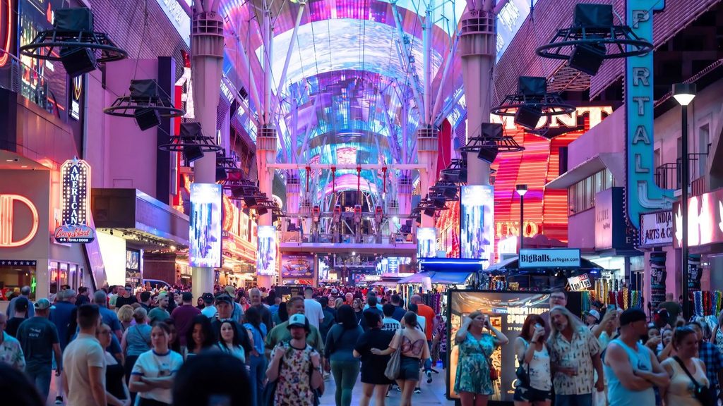 A crowd of people walking beneath the lighted canopy of the Fremont Street Experience in Las Vegas.