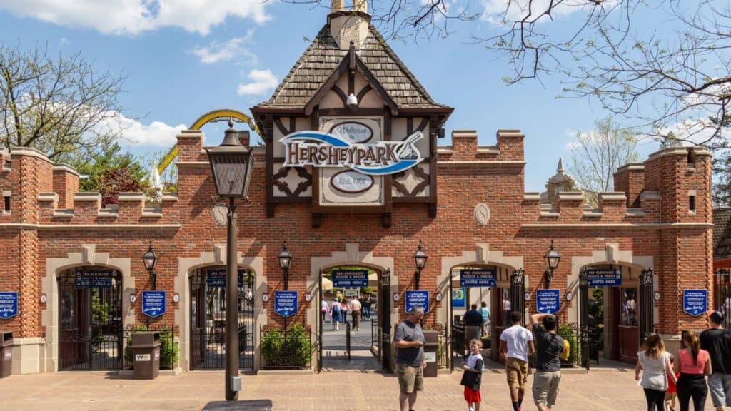 The brick entrance gate to Hersheypark, one of the popular theme parks with Halloween events, features the park logo on the central tower.
