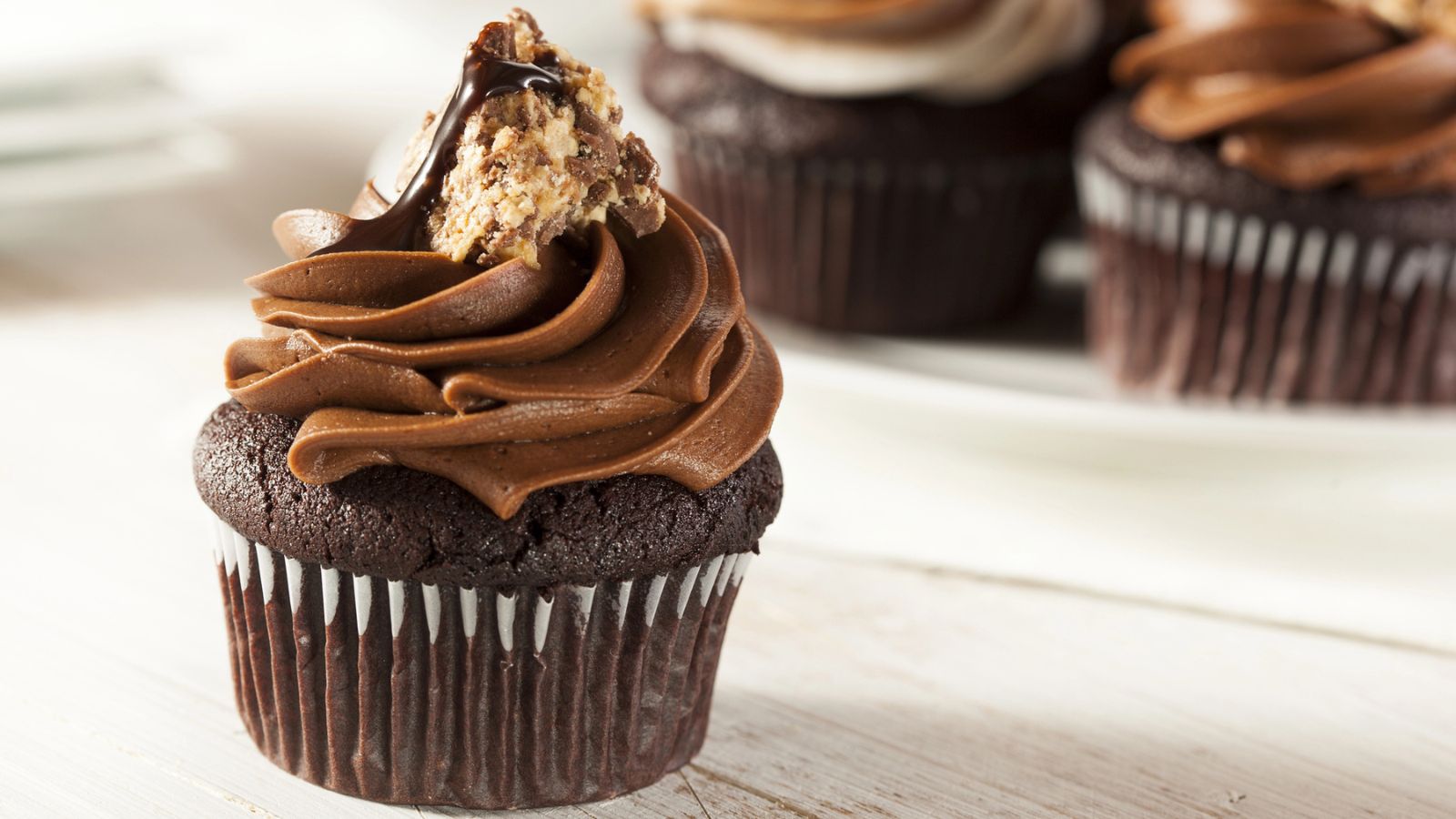 A chocolate cupcake topped with chocolate frosting and a piece of candy, perfect for National Chocolate Cupcake Day.
