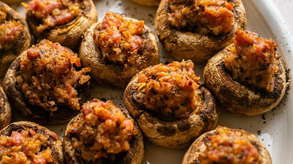 A platter of cooked mushroom caps stuffed with a savory breadcrumb mixture.