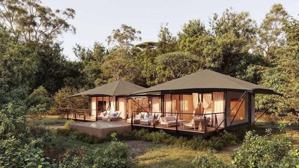 Two luxury safari tents with wooden decks and seating areas located in a forest clearing, perfect for hotel openings in 2027.
