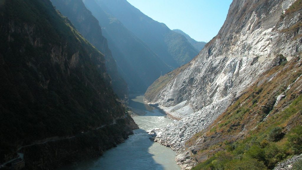 A river flows through a steep, rocky mountain gorge.