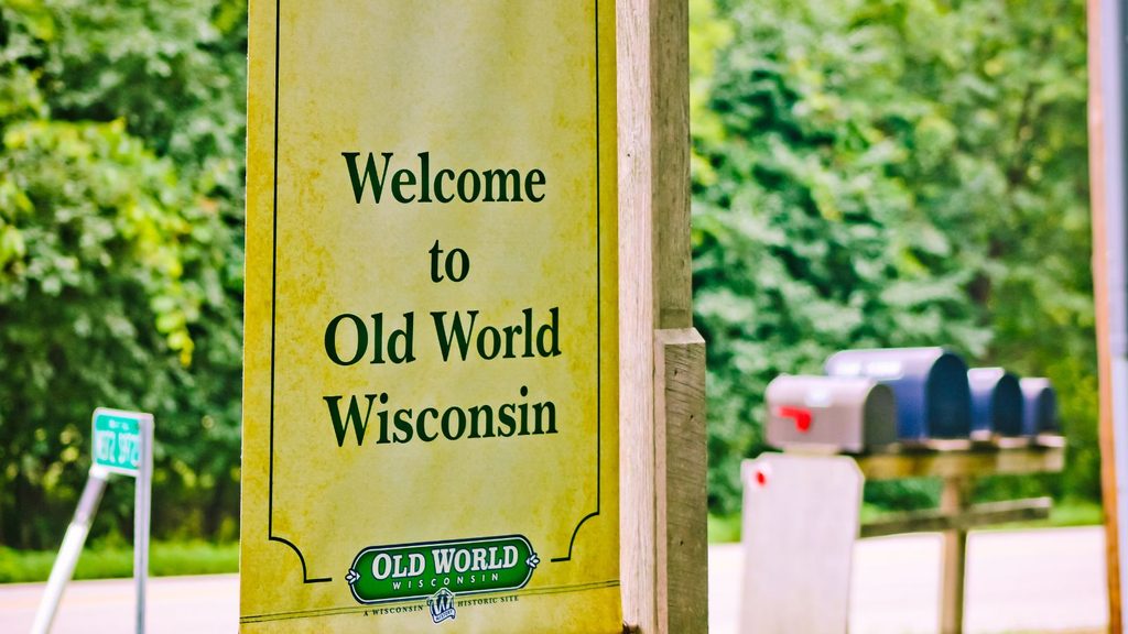 A yellow sign that reads, “Welcome to Old World Wisconsin,” with the site’s logo at the bottom.