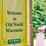 A yellow sign that reads, “Welcome to Old World Wisconsin,” with the site’s logo at the bottom.