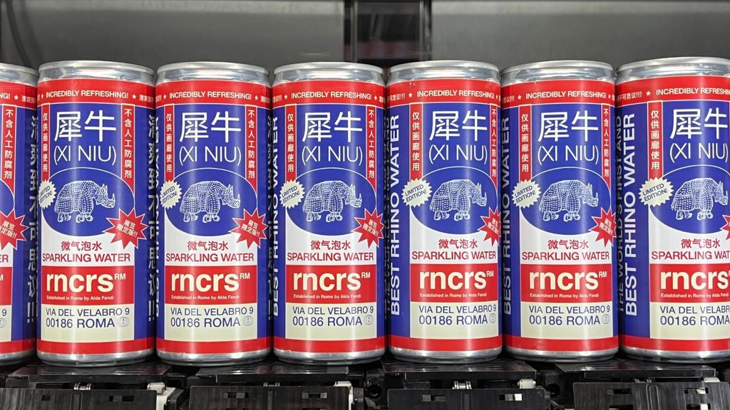 A row of Xi Niu sparkling water cans featuring a blue rhino illustration and red branding on a metal shelf.